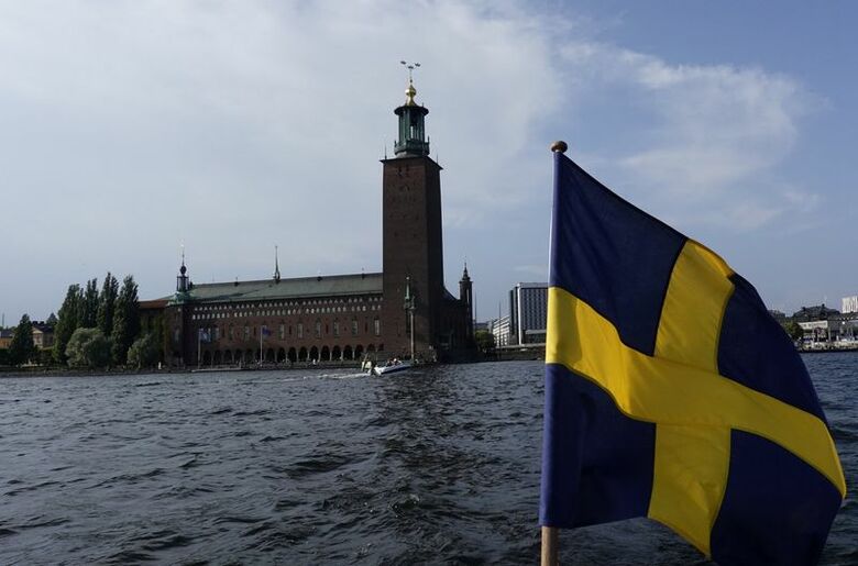 スウェーデン・ストックホルムの市庁舎とスウェーデンの国旗。2025年8月撮影。REUTERS/Leonhard Foeger