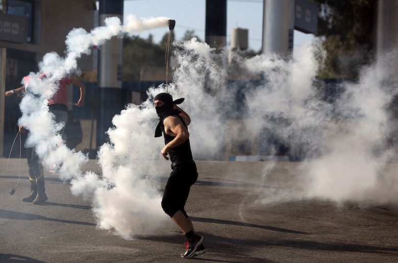 93年のオスロ合意以降もパレスチナの憤懣はくすぶり続けてきた（治安部隊の催涙弾を投げ返そうとするパレスチナの若者）　Mohamad Torokman-REUTERS