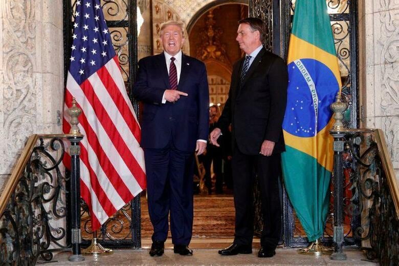 ブラジルのボルソナロ大統領（写真右）の最近の訪米に同行し、トランプ大統領（写真左）のフロリダ州の別荘で7日に開かれた公式会合にも出席したブラジル大統領府の高官が、新型コロナウイルスの検査を受け、結果待ちとなっている。写真はフロリダ州パームビーチで7日撮影（2020年　ロイター／Tom Brenner）