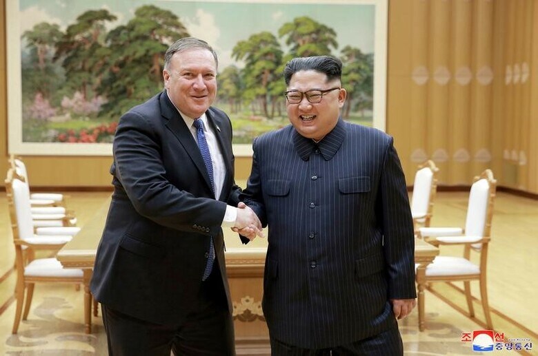 ５月１３日、ポンペオ米国務長官はＣＢＳとのインタビューで、北朝鮮が核開発プログラムを完全に放棄すれば、米国は制裁を解除する用意があるとの考えを示した。写真は９日、平壌で北朝鮮の金正恩・朝鮮労働党委員長と握手するポンペオ氏。ＫＣＮＡ提供（２０１８年　ロイター）