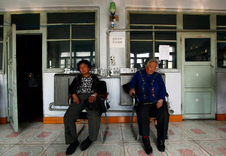 黒竜江省ハルビン市の端に位置する双城区の診療所の前に座る高齢者。中国東北部は貧しい上に高齢者問題がのしかかる（写真は2011年） David Gray-REUTERS 　