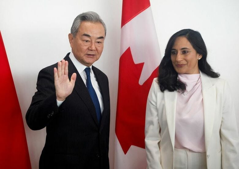 写真は写真撮影で握手する中国の王毅外相とカナダのアナンド外相。オタワで撮影。REUTERS/Patrick Doyle