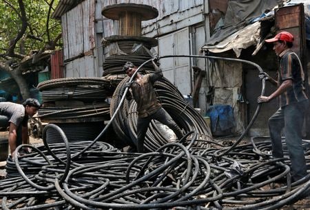 　インドは同国産の鉄鋼や鉄鉱石、セメントに２０─３５％の炭素税を適用するＥＵの案を不服として、世界貿易機関（ＷＴＯ）にＥＵを提訴する計画だ。写真は２０１７年５月、ムンバイで修理作業が終わった後にスチールケーブルを巻く人たち（２０２３年　ロイター／Shailesh Andrade）