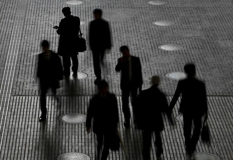 東京のビジネス街にあるオフィスビルを歩く人々。2016年2月、東京で撮影。REUTERS/Yuya Shino