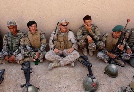 トランプ米大統領は、アフガニスタン駐留米軍の規模を来年１月半ばまでに現在の４５００人から２５００人に大幅に削減する。写真はヘルマンド州での訓練中にアフガニスタン軍の兵士たちと言葉を交わす米海兵隊員（中央）。２０１７年７月撮影（２０２０年　ロイター/Omar Sobhani）