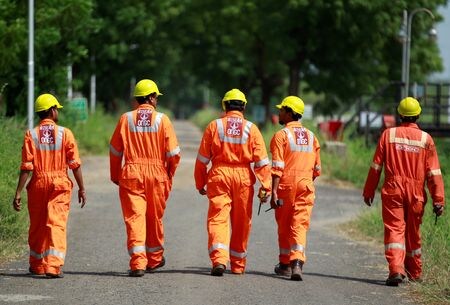 　１０月１７日、インド石油ガス公社（ＯＮＧＣ）は、ロシア極東の石油・天然ガス開発事業「サハリン１」について、ロシア政府が設立した新運営会社に出資し、事業移管前に保有していた権益を維持したい意向だ。写真はアーメダバード郊外にあるＯＮＧＣ施設内を歩く技術者ら。２０１６年９月撮影（２０２２年　ロイター/Amit Dave）