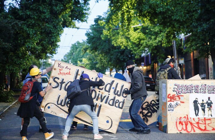 排除にやってくる警官に対抗するためにバリケードを築く「自治区」のデモ参加者　Lindsey Wasson‐REUTERS