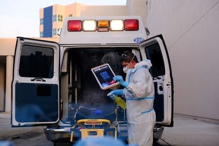 　ロイターの集計によると、米国の新型コロナウイルス感染による入院者数が９日、５万９０００人強と過去最多を更新した。写真は機器を消毒する救急隊員。７月米フロリダ州ペンブロークパインズで撮影（２０２０年　ロイター/Maria Alejandra Cardona）