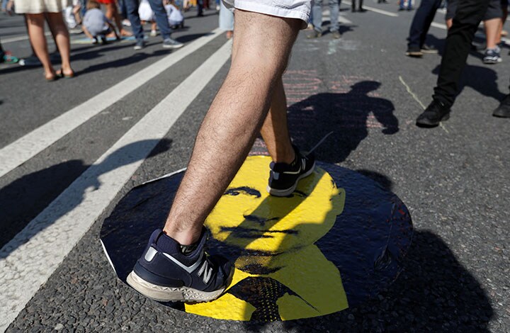 年金支給開始年齢の引き上げに抗議してプーチンの顔を踏むデモ参加者（7月29日、モスクワ）　Sergei Karpukhin-REUTERS