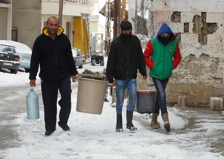 レバノン南部の村で、暖を取るための薪木を運ぶ親子　Aziz Taher-REUTERS