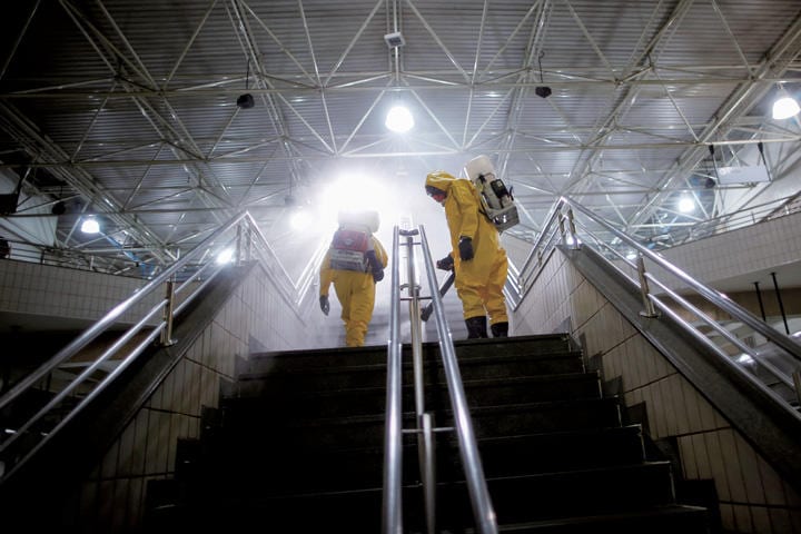 コロナは人類の救いに？（ブラジルの地下鉄で消毒作業を行う作業員）　UESLEI MARCELINO-REUTERS