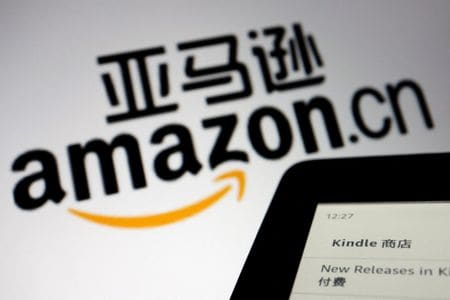 米ネット通販大手アマゾン・ドット・コムの電子書籍部門キンドルは２日、中国でのサービスを来年６月末で停止すると発表した。アマゾン中国のウェブサイトのイラストとキンドルの端末。２０２１年１２月撮影。（2022年 ロイター/Florence Lo/Illustration ）
