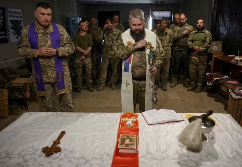 ４月２０日、ロシアのプーチン大統領が復活祭に合わせて宣言したウクライナでの停戦を巡り、両国は、相手が攻撃を続けていると互いに非難した。写真は、ドネツクでのイースター礼拝に出席するウクライナ軍の兵士ら。同日、ドネツクで撮影（２０２５年　ロイター/Anatolii Stepanov）