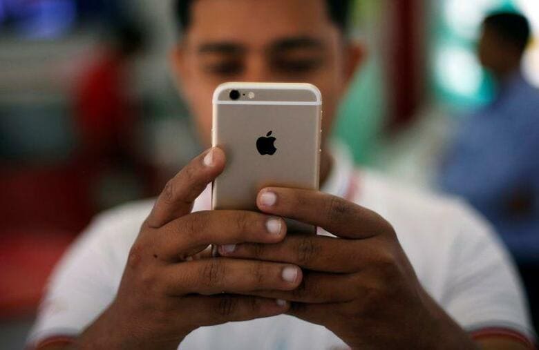 インド当局が中国から輸入する電子製品に対する品質管理規格の認証を厳格化しているため、アップルの新型iPhoneの輸入に先月、遅延が生じたほか、中国の小米（シャオミ）などの企業の製品も悪影響を受けたことが、業界筋2人の話で明らかになった。写真はニューデリー市内でiPhoneを操作する男性。2016年7月27日に撮影。（2020年ロイター／Adnan Abidi）