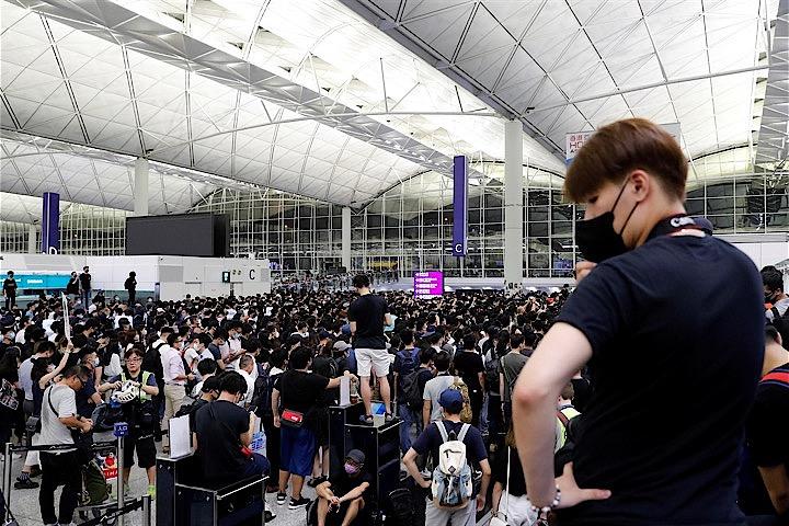 香港では今週末も反政府デモが予定されている。当局が交通を妨げる活動に警告を発する中、香港国際空港では「ストレステスト」が実施されそうだ。写真は「逃亡犯条例」の改正案に反対し香港の国際空港でデモに参加する人々。13日撮影（2019年　ロイター／Tyrone Siu）
