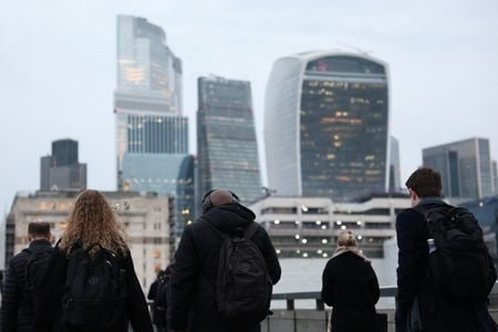 2025年12月16日、英国ロンドンで、朝のラッシュアワーにロンドン橋を渡る労働者と、その背後に見えるロンドン金融街の高層ビル群。ロイター/トビー・メルビル