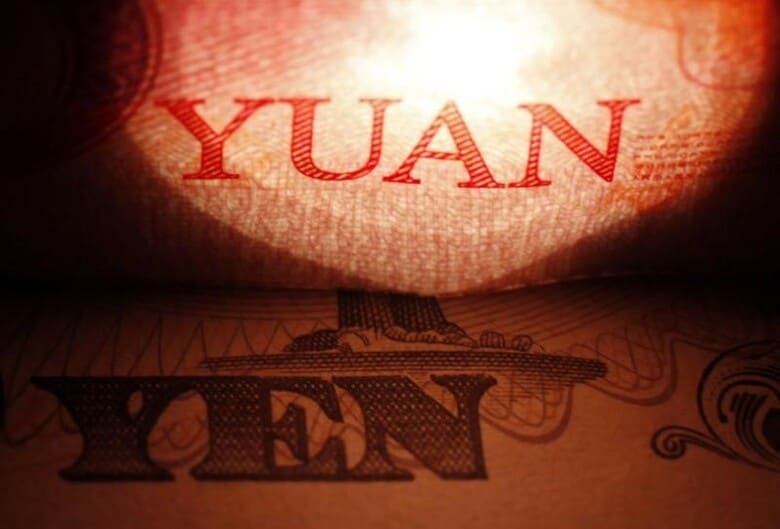 ２月１日、日銀のマイナス金利導入を受け、ヘッジファンドの間で中国人民元が切り下げられるとの観測が広まっている。写真は人民元、円紙幣。２０１２年５月撮影。（２０１６年　ロイター／ Issei Kato）