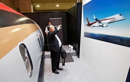　１月２０日、三菱重工業の子会社が開発を進めている国産ジェット旅客機「ＭＲＪ（三菱リージョナルジェット）」について、２０１８年半ばを予定していた航空会社への初号機の納入時期が最大で２０年半ばに延期される見通しとなった。納期の延期は５回目。見本市で訪問客がポスターの写真を撮る様子。都内で昨年１０月撮影（２０１７年　ロイター/Kim Kyung Hoon）