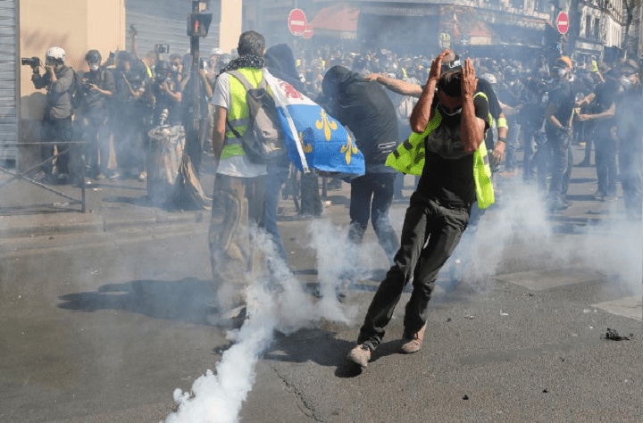 4月20日、フランスのパリで、マクロン政権に抗議する「黄色いベスト運動」の23週目のデモが行われ、デモ隊数十人と警官隊が衝突した。写真は催涙ガスの雲の中のデモ隊。パリで撮影（2019年　ロイター／Yves Herman）