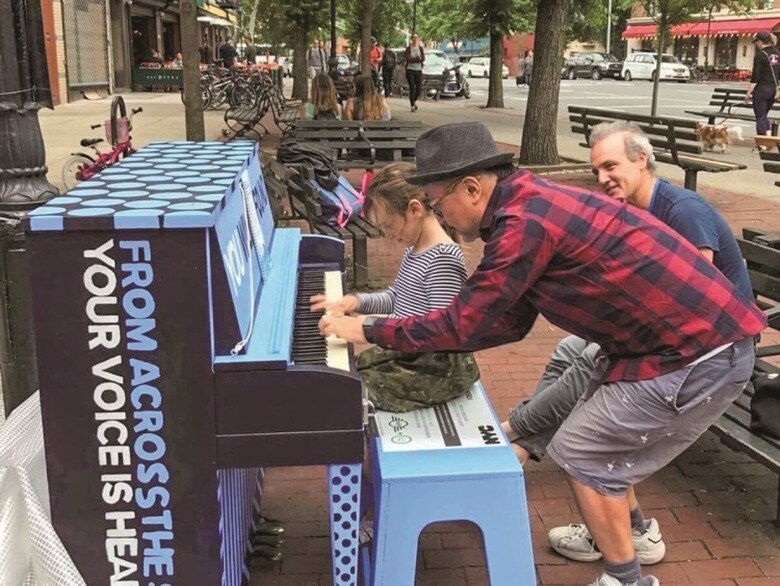 少女と一緒にニューヨークの街角ピアノを弾く筆者　SENRI OE