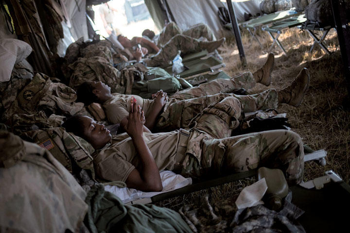 メキシコ国境のダナ・ベースキャンプでスマホをいじる米軍兵士　ADREES LATIF-REUTERS