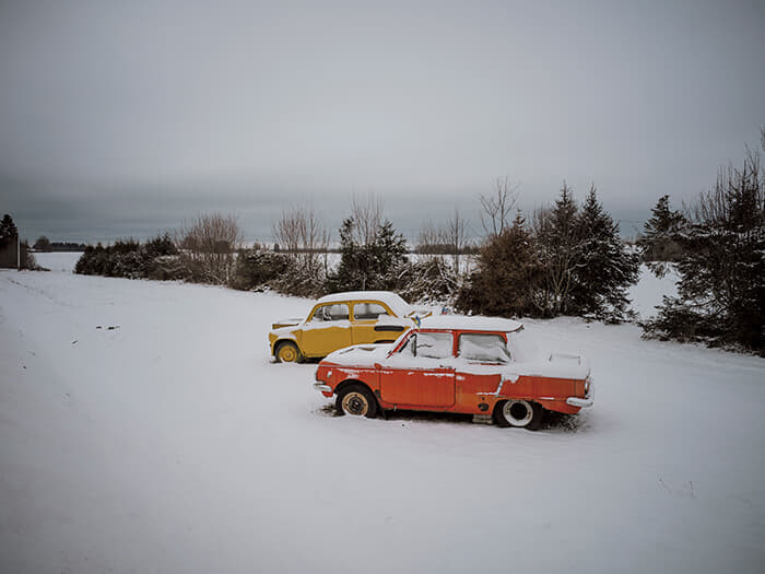 雪に閉ざされた道路脇にはソ連時代の自動車2台が放置され、うち1台には小さなウクライナ国旗が飾られていた。2022年のロシアによるウクライナ侵攻以降、エストニアは強力なウクライナ支持国となり、GDP比では首位となる軍事支援を続けている。偶然にもナルバ市の旗はウクライナ国旗を逆さにしたような黄色と青色の2色旗だ