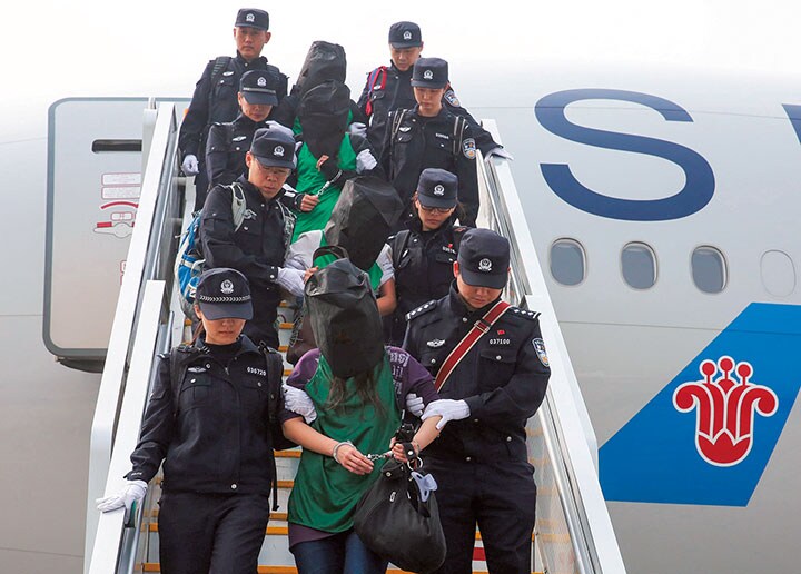 ケニアから中国に移送され、警察官に護送される台湾人ら　Yin Gang-Xinhua-REUTERS