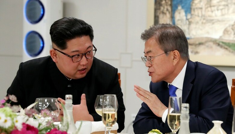 ５月１６日、北朝鮮国営の朝鮮中央通信（ＫＣＮＡ）は、米政府が北朝鮮の核プログラム放棄を一方的に主張し続けるならば、北朝鮮は米国との首脳会談開催を再考するかもしれない、と伝えた。写真は４月２７日の南北首脳会談の夕食会での北朝鮮の金正恩委員長と韓国の文在寅大統領。代表撮影（２０１８年　ロイター）