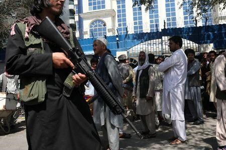 アフガニスタンのイスラム主義組織タリバンは４日、唯一制圧していない北東部パンジシール州を支配下におさめようと抵抗勢力と衝突した。写真は首都カブールの銀行の前でライフルを持ち秩序を維持するタリバンのメンバー。４日撮影。ＷＡＮＡ提供（２０２１年　ロイター）