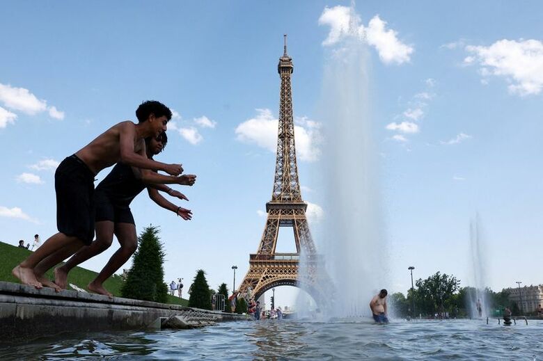パリのエッフェル塔近くの噴水で涼をとる人々、22日撮影　REUTERS/Abdul Saboor