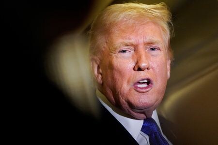 大統領専用機「エアフォースワン」の機内で記者団に応じるトランプ米大統領。１６日撮影。REUTERS/Elizabeth Frantz