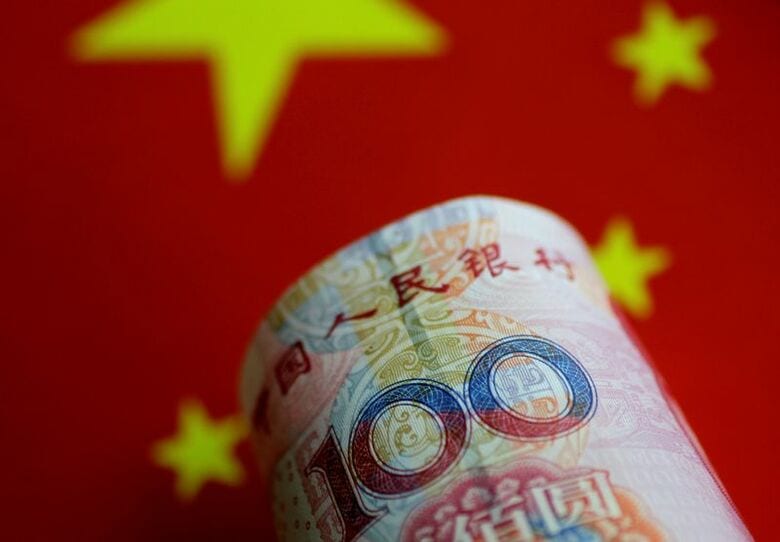 写真は中国元紙幣と国旗のイメージ。2017年5月撮影。REUTERS/Thomas White