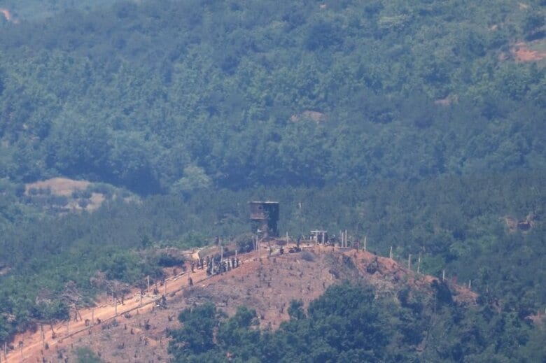 北朝鮮の人々が南北国境の警備所付近で軍事フェンスの建設作業をしている様子。2024年6月4日、韓国の坡州市にある南北を隔てる非武装地帯近くの展望台から撮影。 REUTERS/Kim Hong-Ji