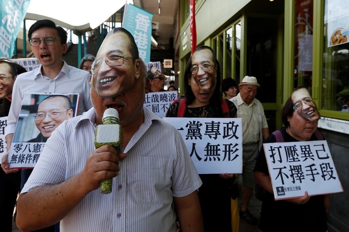 劉暁波のお面をかぶって中国の圧政に抗議する香港市民（6月27日）　Bobby Yip-REUTERS