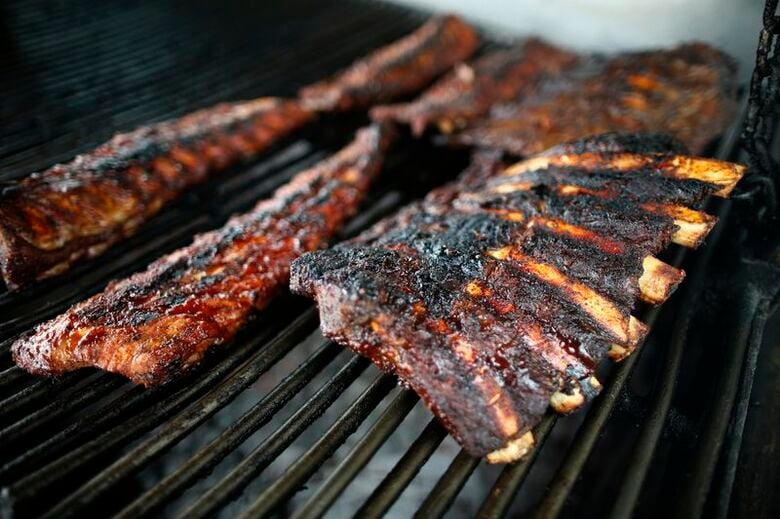 ロサンゼルスのレストランのグリルで調理される牛肉と豚肉のリブ。2014年4月10日撮影　REUTERS/Lucy Nicholson