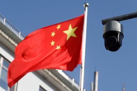 １０月１７日、 中国当局が公務員や国有企業職員の私的な海外旅行を制限している。写真は中国の旗と監視カメラ。北京で２０２１年１１月撮影（２０２３年　ロイター/Carlos Garcia Rawlins）