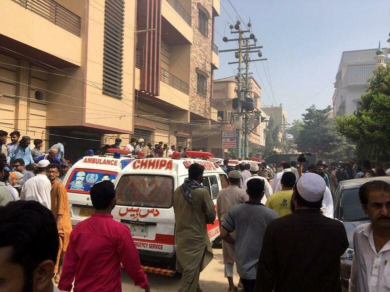 パキスタン南部カラチの住宅街にパキスタン国際航空の旅客機が墜落した。同社広報によると、墜落したのは8303便で、乗客99人、乗員8人。写真は空港近くの住宅街に集まる人々と救急車。5月22日撮影(2020年　ロイター/Akhtar Soomro)
