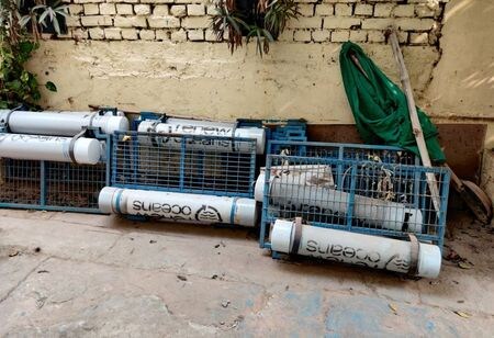 　インドのガンジス川から歩いてすぐの距離にあるバラナシ市の事務所は無人で、南京錠が掛かっている。事務所の外には「リニュー・オーシャンズ」と書かれた手押し車やゴミ収集用の金属網が無造作に置かれ、錆びるがままに放置されている。写真は事務所の前に置かれたゴミ収集用の容器。昨年１２月撮影（２０２１年　ロイター／Saurabh Sharma）