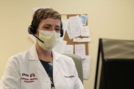 ９月１４日、新型コロナウイルスによるパンデミック（世界的な流行）が米国の小さな街や辺境の村落にも広がる中、タルラー・ホルムストローム医師が働くサウスカロライナ州カーショー郡カムデンの集中治療室も、顔見知りの患者で埋まっていくようになった。写真は３日、米カリフォルニア州サクラメントの医療法人サッターヘルスの医療施設で、遠隔診療を行うバネッサ・ウォーカー医師（２０２０年　ロイター/Nathan Frandino)