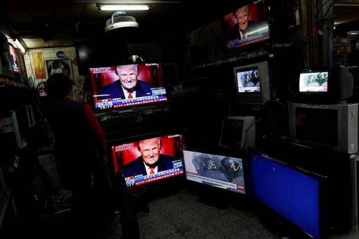 １月２２日、米ホワイトハウスは、トランプ大統領の就任式の観客数をめぐるメディア報道について、政権に対する不当な攻撃だと批判し、「全力で」戦う姿勢を示した。写真はトランプ大統領を映すテレビ画面、台北で２１日撮影（２０１７年　ロイター/Tyrone Siu）