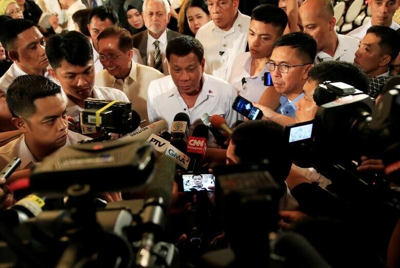 ７月１８日、フィリピンのドゥテルテ大統領（中央）は、南部ミンダナオ島のマラウイを占拠する過激派組織「イスラム国」（ＩＳ）系武装勢力の鎮圧に向け、同島に出した戒厳令を今年末まで延長するよう議会に要請した。写真は記者会見に応じる同大統領。１７日マニラで撮影（２０１７年　ロイター／Romeo Ranoco）