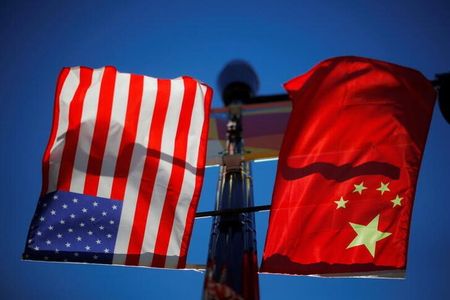 ３月１１日、米中当局による企業監査と規制での協力について、関係筋は協議が順調に進んでいると明らかにした。写真は米国と中国の旗。米ボストンで２０２１年１１月撮影（２０２２年　ロイター/Brian Snyder）
