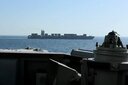 ホルムズ海峡近くで、米海軍ミサイル駆逐艦（手前）とイラン船籍の貨物船「トゥスカ」（2026年4月19日に公開された動画からのキャプチャ）　 CENTCOM/Handout via REUTERS
