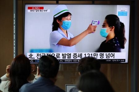 　北朝鮮が初めて確認した新型コロナウイルス感染は、４月に平壌で行われた大規模な軍事パレードの後に広がったと、韓国の通信社ニューシスが国内情報機関から説明を受けた議員らの話として伝えた。ソウルの駅で、北朝鮮のコロナ拡大に関するニュースを見る人々。５月１７日撮影（２０２２年　ロイター／Kim Hong-Ji）