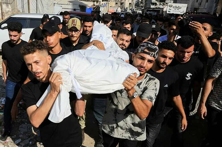 ガザ市で、イスラエル軍の攻撃で死亡したというパレスチナ人の遺体を運ぶ弔問客。8月2日撮影。REUTERS/Dawoud Abu Alkas