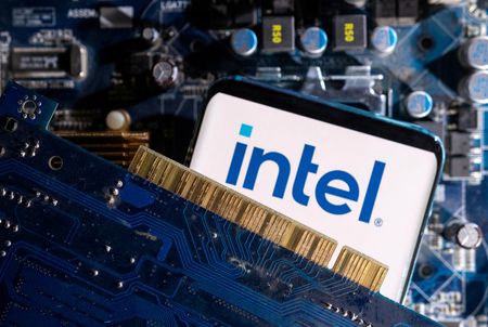 　１１月７日、米半導体大手インテルはベトナムの半導体事業をほぼ２倍に拡大する投資計画を棚上げした。写真はコンピューターのマザーボード上に置かれたインテルのロゴが表示されたスマートフォン。３月撮影（２０２３年　ロイター/Dado Ruvic）