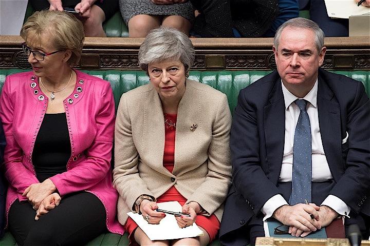 メイ英首相（写真中央）が欧州連合（ＥＵ）と合意した離脱協定案が英議会で三たび否決されたことを受け、首相は合意のないまま離脱するか、一段と穏健な離脱を交渉するか、総選挙の前倒し実施を決断するか迫られている。英議会で２９日撮影。英議会提供（２０１９年　ロイター）