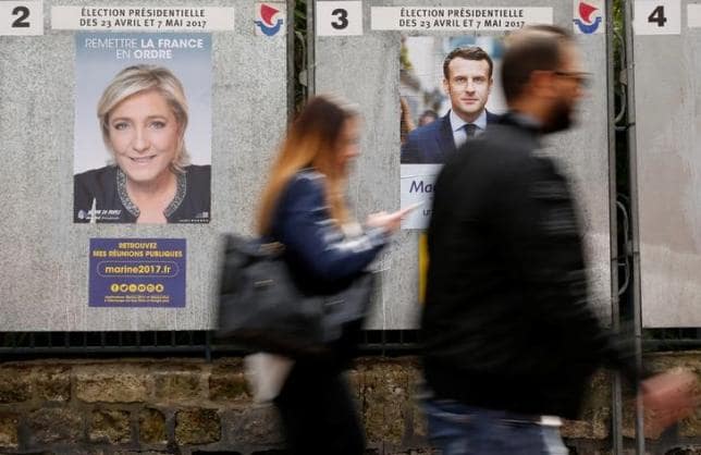 ４月１９日、フランス政治研究センター（ＣＥＶＩＰＯＦ）がルモンド紙の委託で実施した世論調査によると、２３日に行われる仏大統領選第１回投票の支持率は、中道系独立候補のマクロン前経済相と極右政党・国民戦線（ＦＮ）のルペン党首が他候補に対するリードを僅かに保っている。写真はパリ市内の選挙ポスター。１０日撮影（２０１７年　ロイター／GONZALO FUENTES）