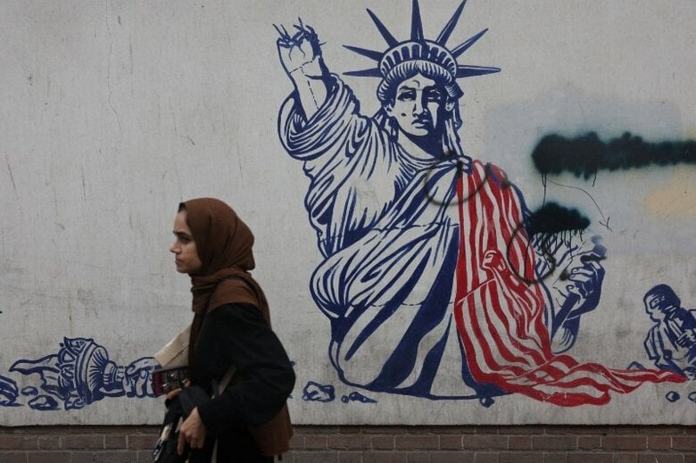 9月9日、イランのテヘランで、反米壁画の前を歩く女性。Majid Asgaripour/WANA (West Asia News Agency) via REUTERS