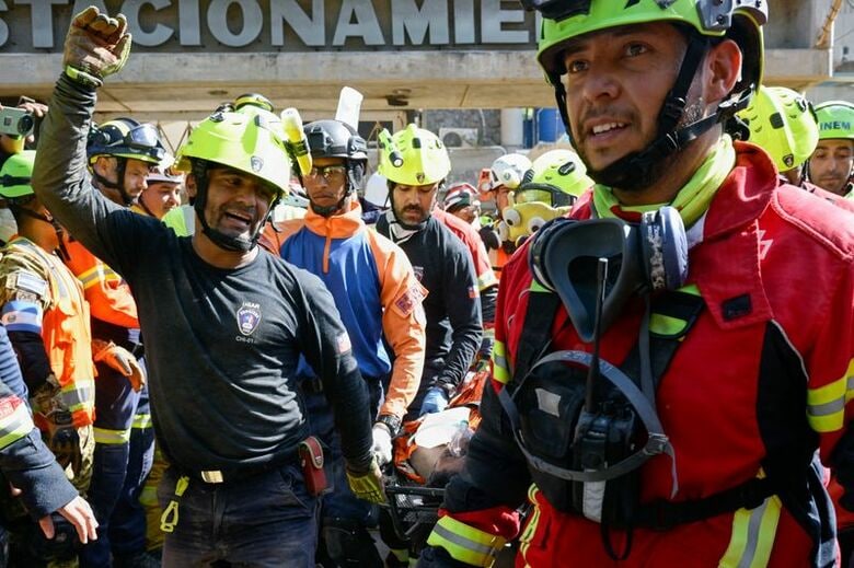 写真は救出された男性を運ぶ救助隊員。7月2日、ベネズエラのラ・グアイラで撮影。REUTERS/Maxwell Briceno